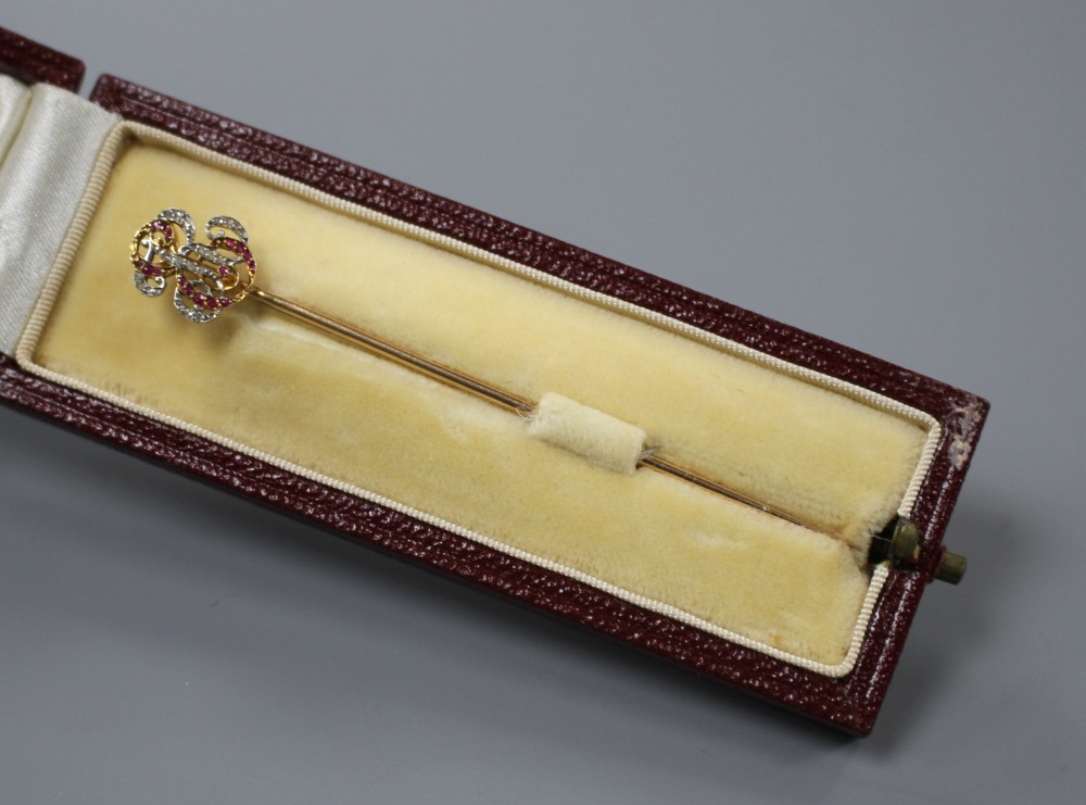 An early 20th century French yellow metal (poincon marks for 18ct), ruby and diamond stick pin, with ER? monogram terminal,